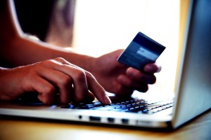 Hands holding credit card and using laptop. Online shopping